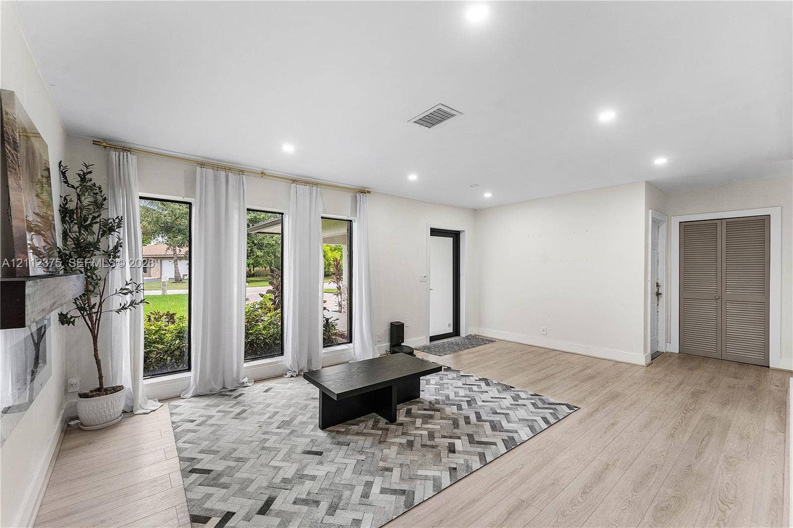 10936 NW 41st Drive, Coral Springs, Coral Springs, FL 33065 Living area featuring wood-finish flooring, recessed lighting, triple floor-to-ceiling windows, and dual-panel closet doors