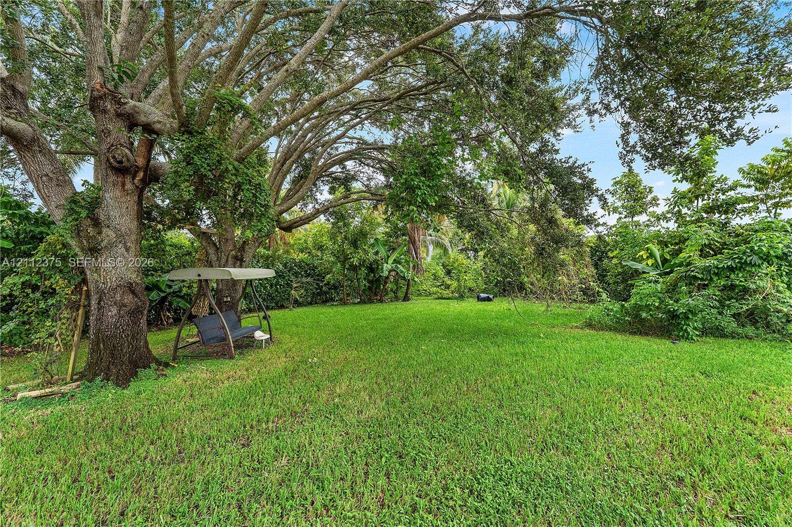 10936 NW 41st Drive, Coral Springs, Coral Springs, FL 33065 Expansive green lawn featuring mature shade trees and dense perimeter landscaping