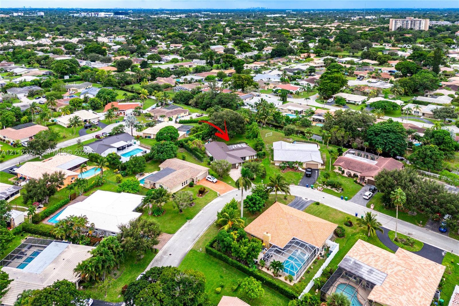 10936 NW 41st Drive, Coral Springs, Coral Springs, FL 33065 Aerial perspective of a residential property featuring a pitched roof, attached garage, paved driveway, and mature landscaping within a suburban setting