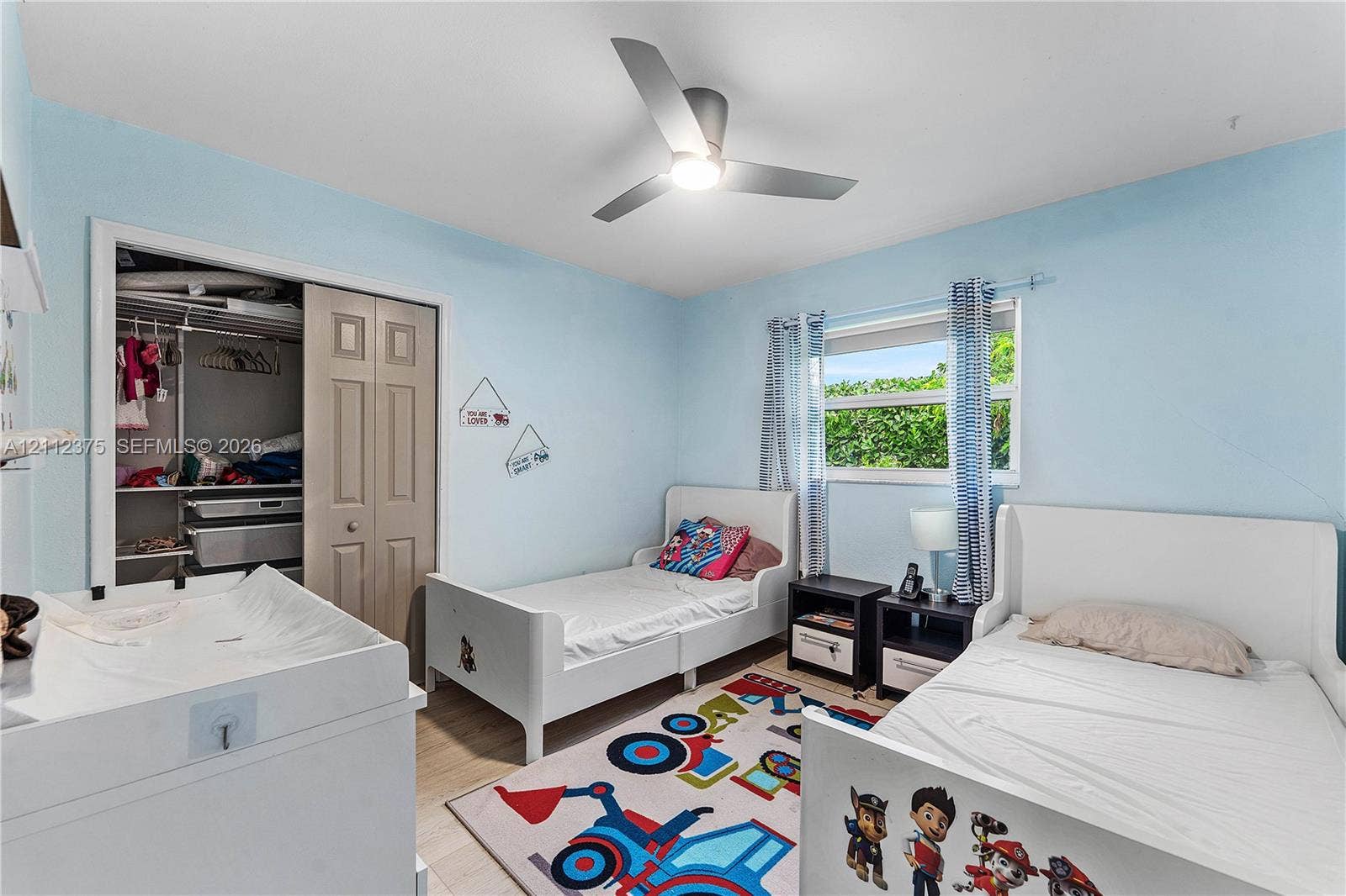 10936 NW 41st Drive, Coral Springs, Coral Springs, FL 33065 Bedroom featuring wood-finish flooring, a contemporary three-blade ceiling fan with integrated lighting, and a closet with bifold doors