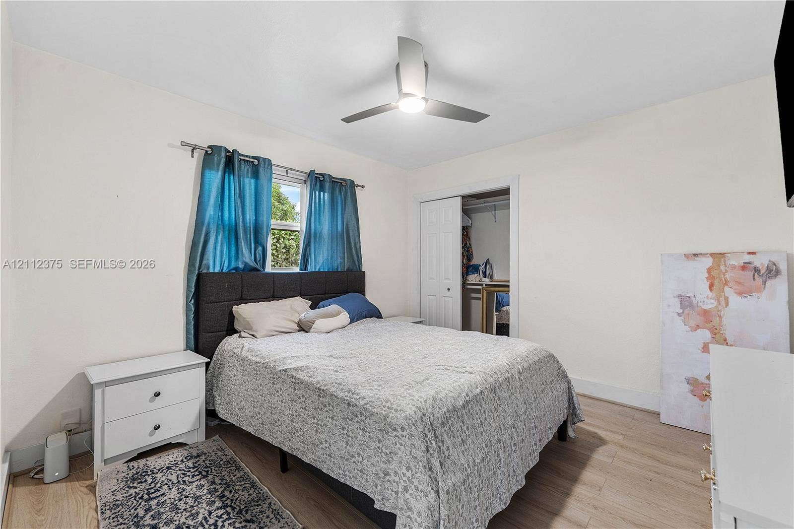 10936 NW 41st Drive, Coral Springs, Coral Springs, FL 33065 Light-filled room featuring wood-finish flooring, a ceiling fan with integrated lighting, and a closet with paneled doors