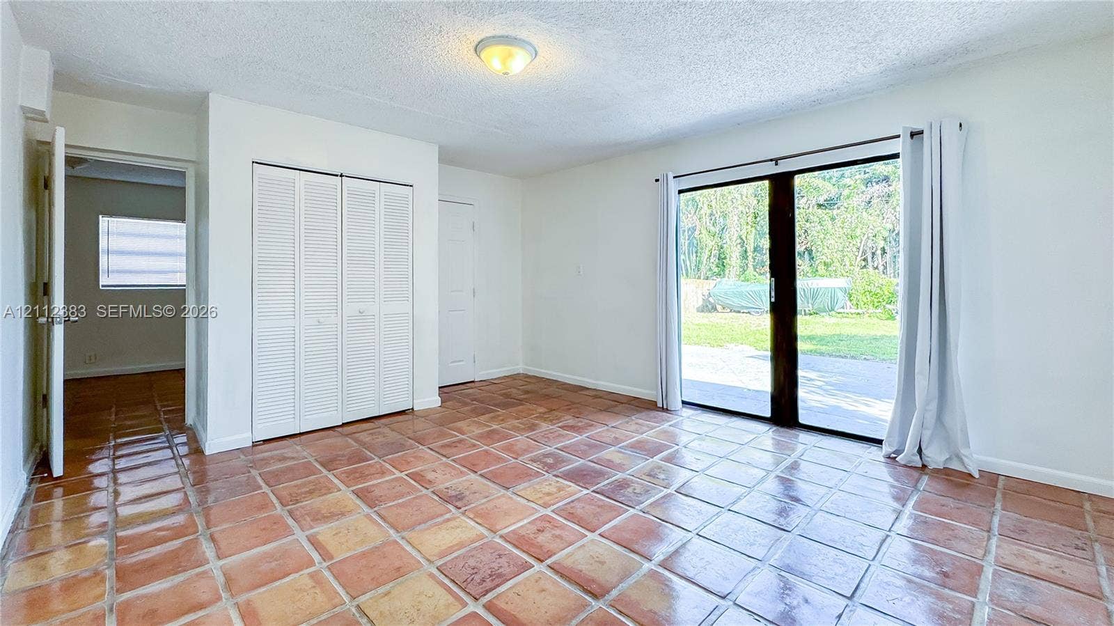 5319 Lake Boulevard, Delray Beach, Delray Beach, FL 33484 Ceramic tile flooring, sliding glass door, white bifold closet doors, and flush-mount ceiling lighting