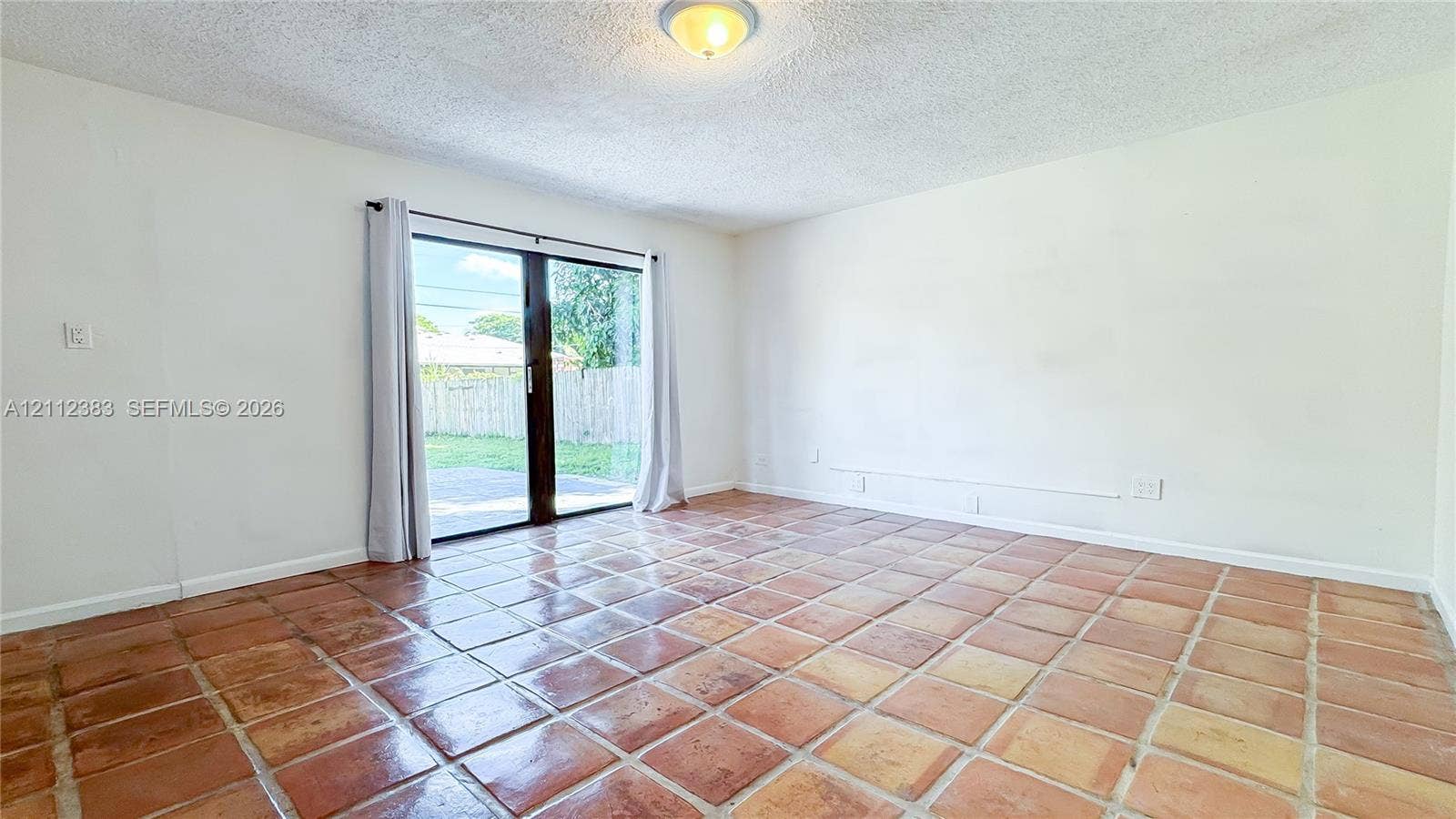5319 Lake Boulevard, Delray Beach, Delray Beach, FL 33484 Interior room featuring terracotta tile flooring, sliding glass door, flush-mount lighting, and neutral wall paint
