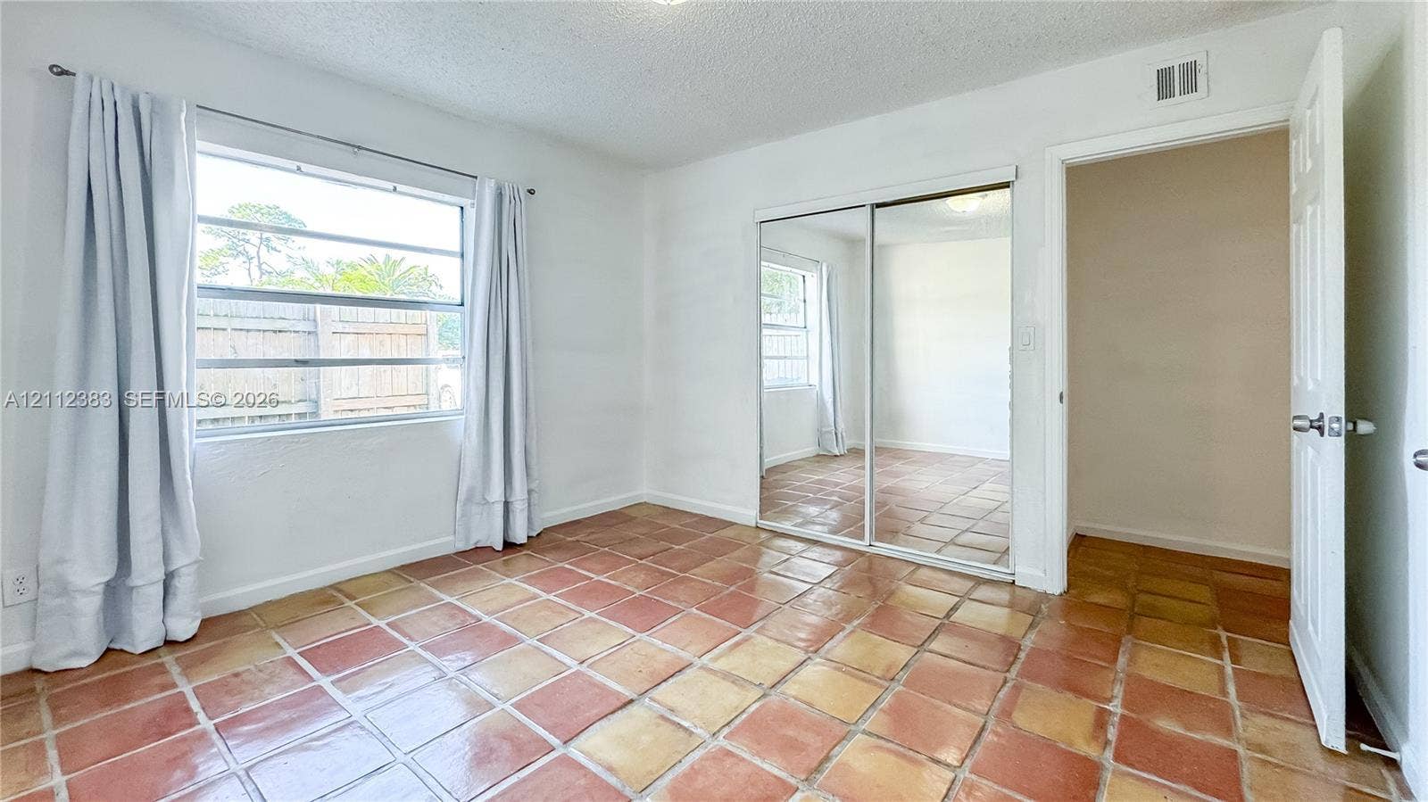 5319 Lake Boulevard, Delray Beach, Delray Beach, FL 33484 Interior room featuring tile flooring, sliding mirrored closet doors, and multi-pane window