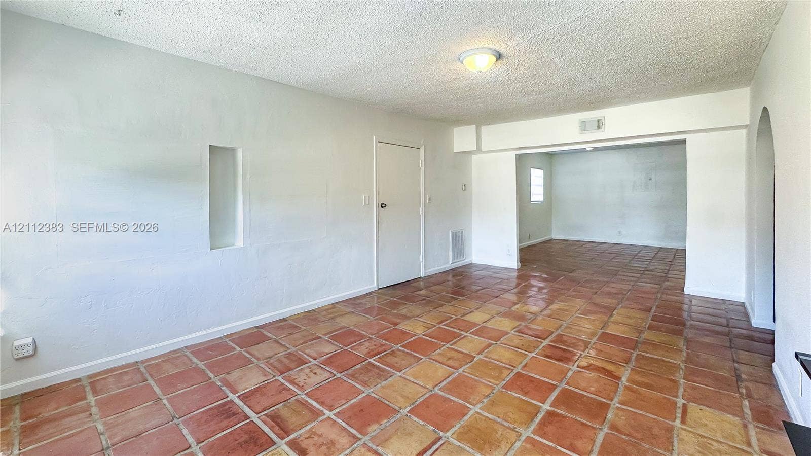 5319 Lake Boulevard, Delray Beach, Delray Beach, FL 33484 Interior featuring terra-cotta tile flooring, arched wall opening, recessed wall niche, and flush-mount ceiling lighting