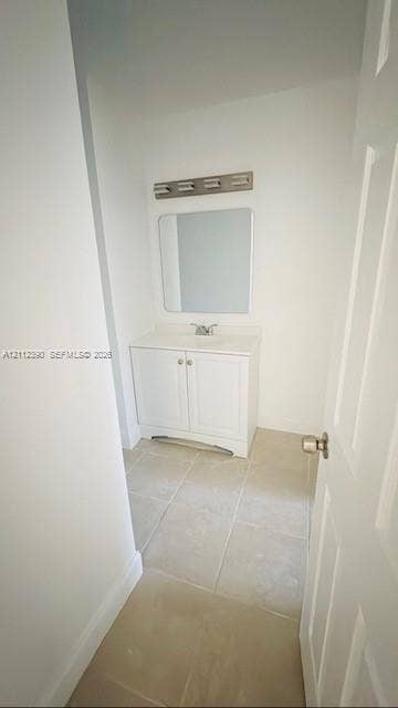 10765 Cleary Boulevard, #305, Plantation, Plantation, FL 33324 White vanity cabinet with a solid surface countertop, rectangular mirror, multi-bulb vanity light, and neutral tile flooring