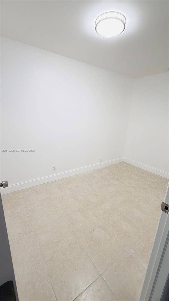 10765 Cleary Boulevard, #305, Plantation, Plantation, FL 33324 Neutral-toned tile flooring, white wall finishes, and a flush-mount dome ceiling light fixture