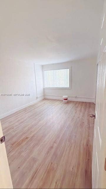 10765 Cleary Boulevard, #305, Plantation, Plantation, FL 33324 Interior space featuring wood-finish flooring, white walls, and a large window with vertical blinds