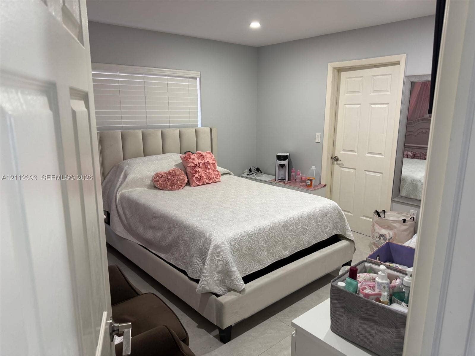 Neutral-toned interior featuring recessed lighting, a multi-panel interior door, and large-format tile flooring