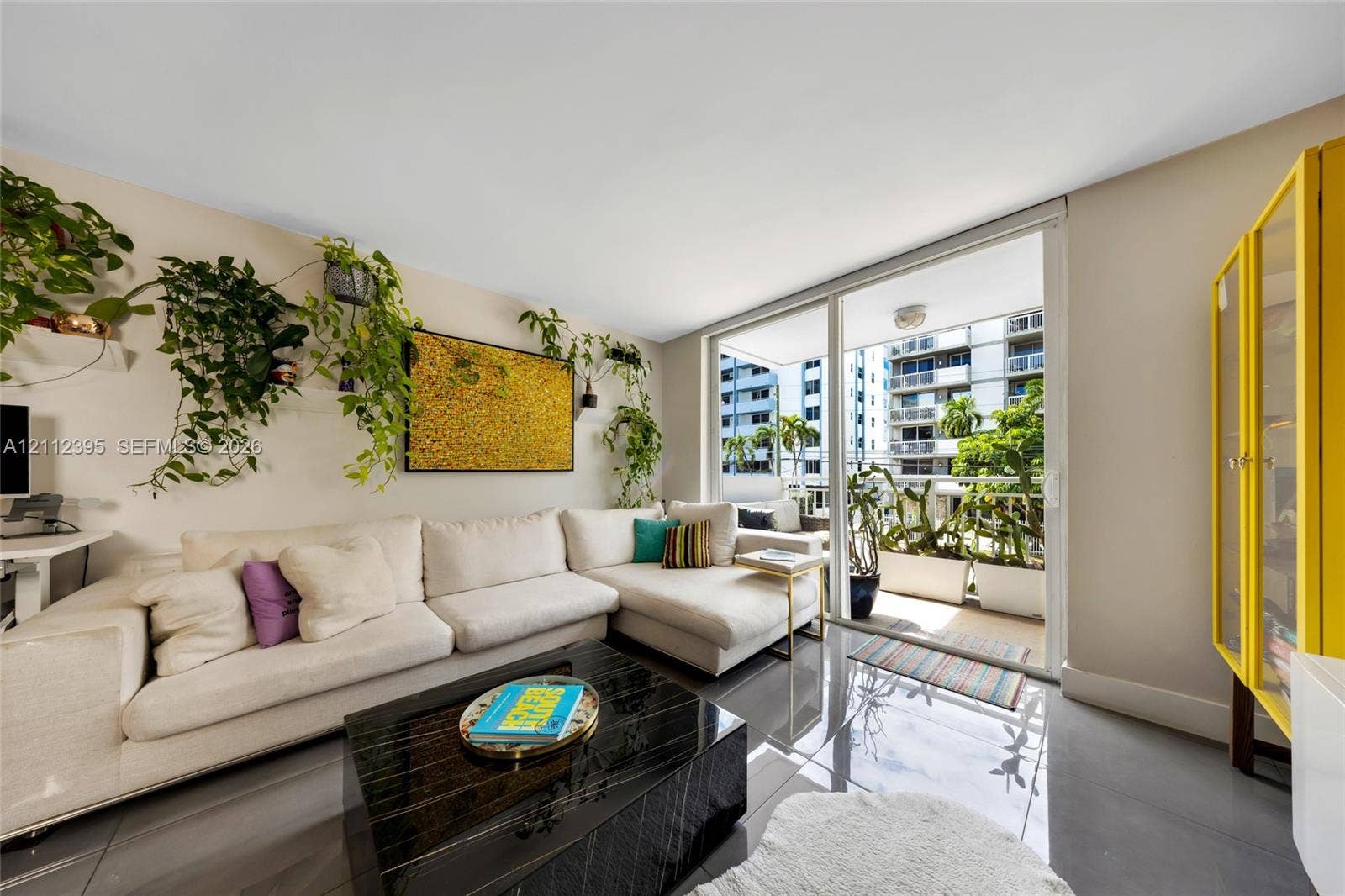 Living area featuring polished tile flooring, sliding glass doors, and a private balcony