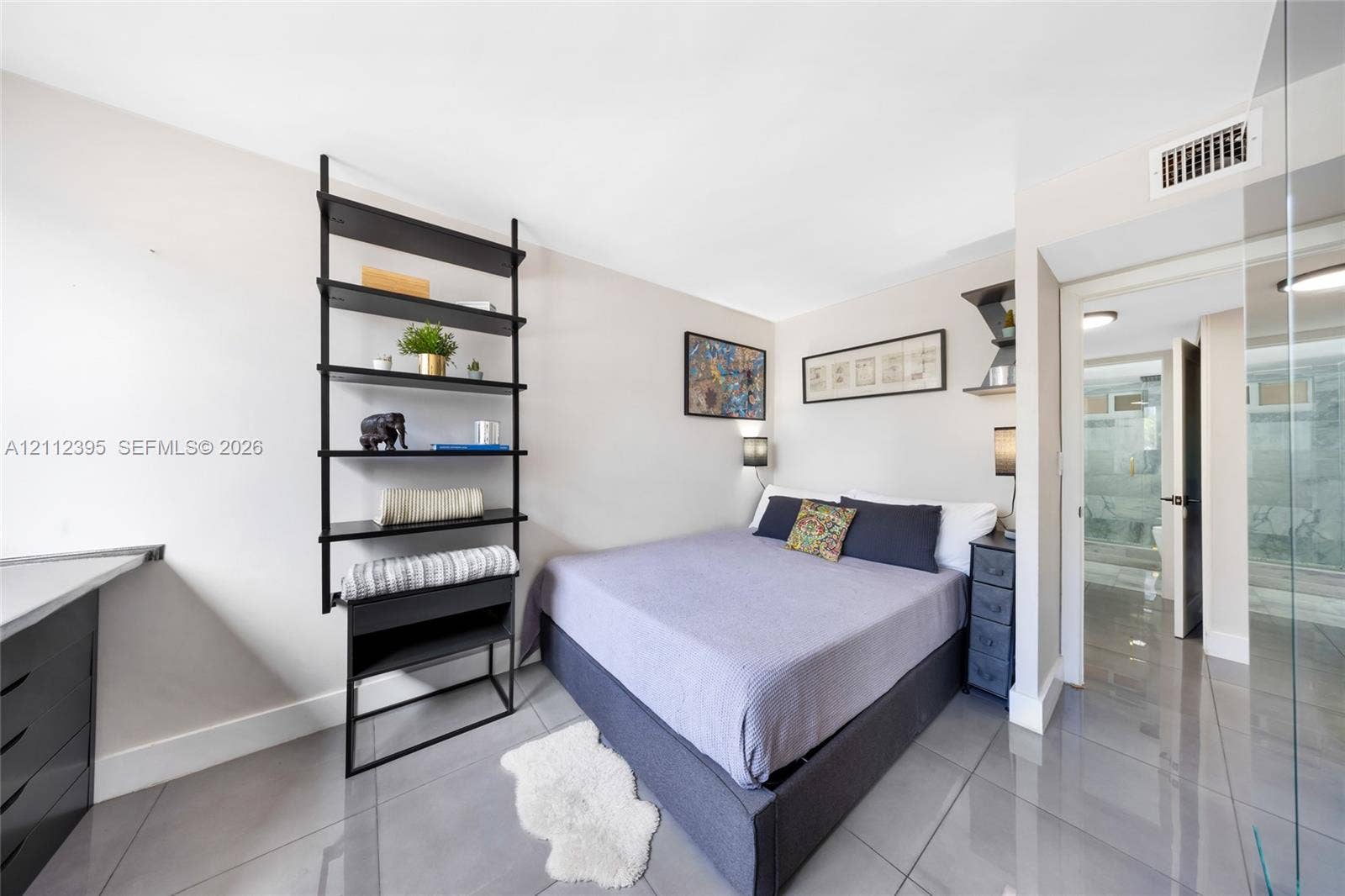 Polished tile flooring, wall-mounted black metal shelving, and sleek built-in desk cabinetry