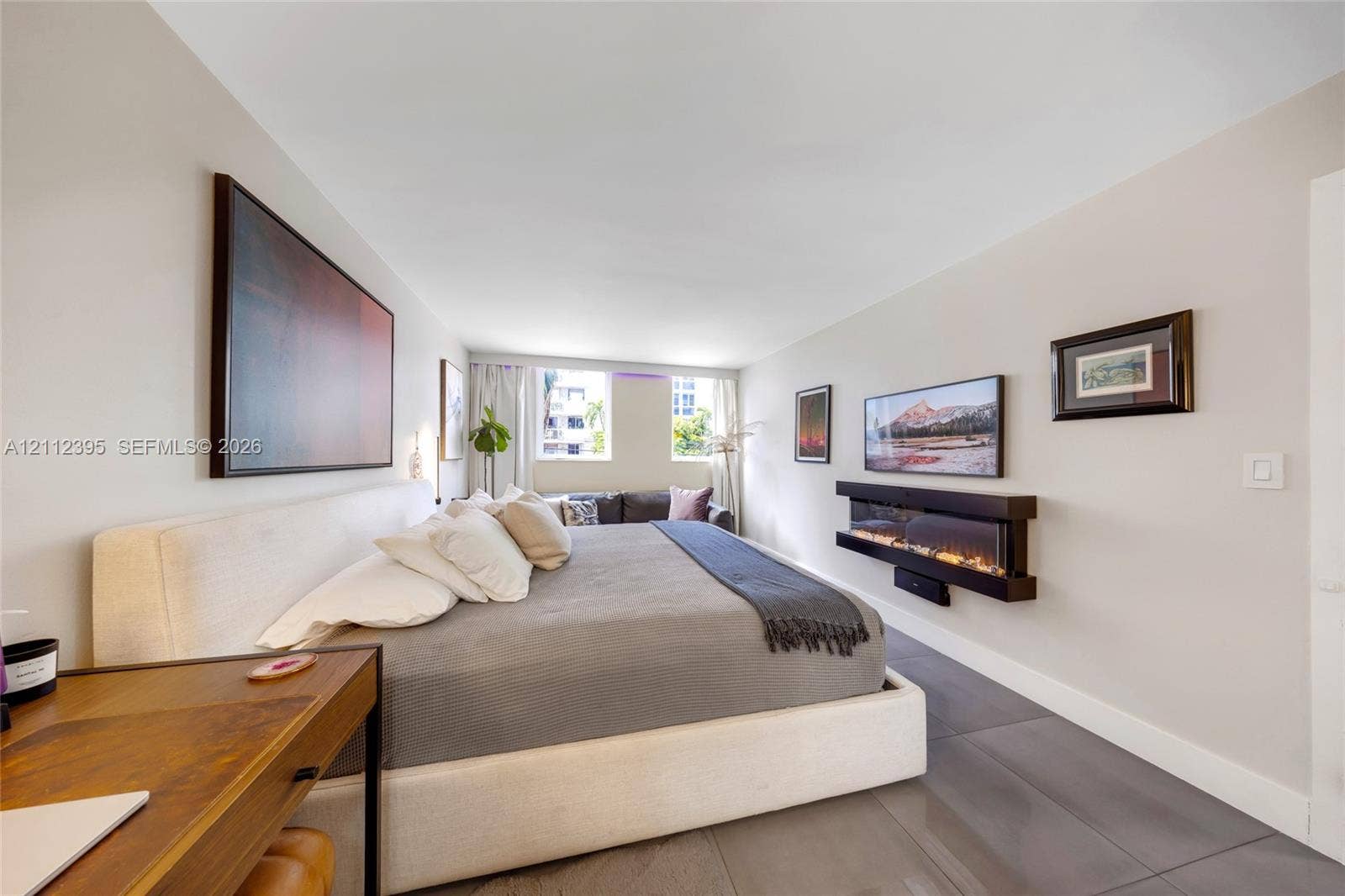 Wall-mounted electric fireplace, neutral interior paint, and large-format tile flooring
