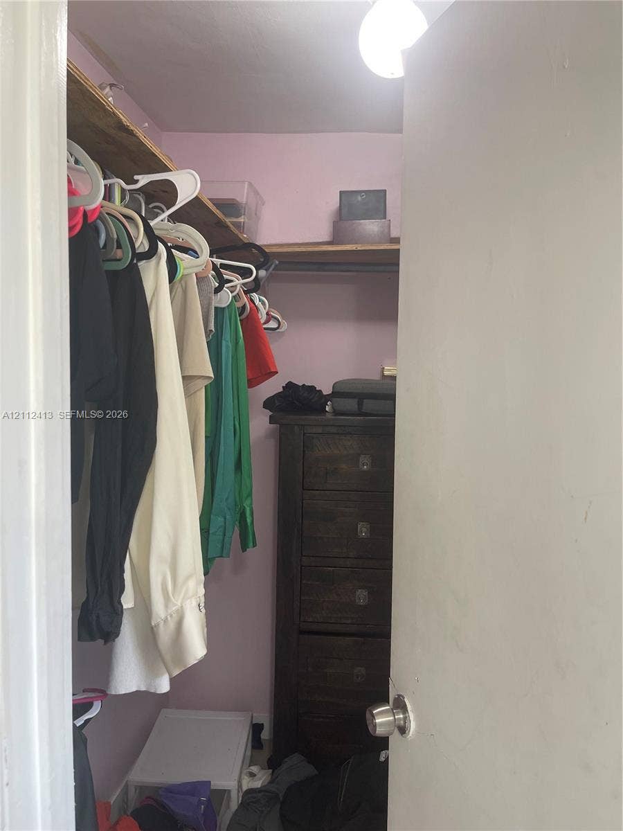 10830 Westwood Lake Drive, #0, Miami, Miami, FL 33165 Walk-in closet featuring upper wooden shelving and a flush-mount overhead light fixture