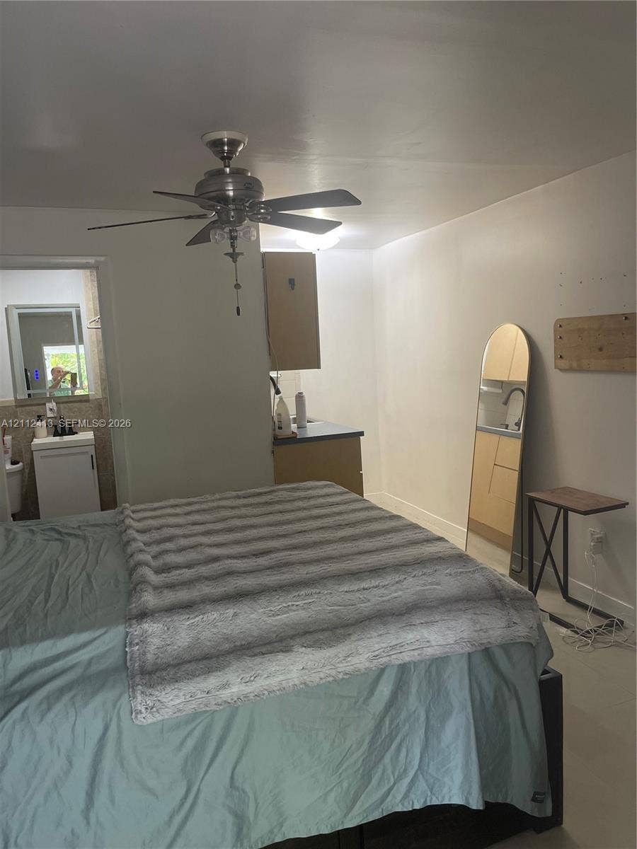 10830 Westwood Lake Drive, #0, Miami, Miami, FL 33165 Room featuring a ceiling fan with integrated lighting, wood-finish cabinetry, and a pedestal sink with a dark-finished faucet
