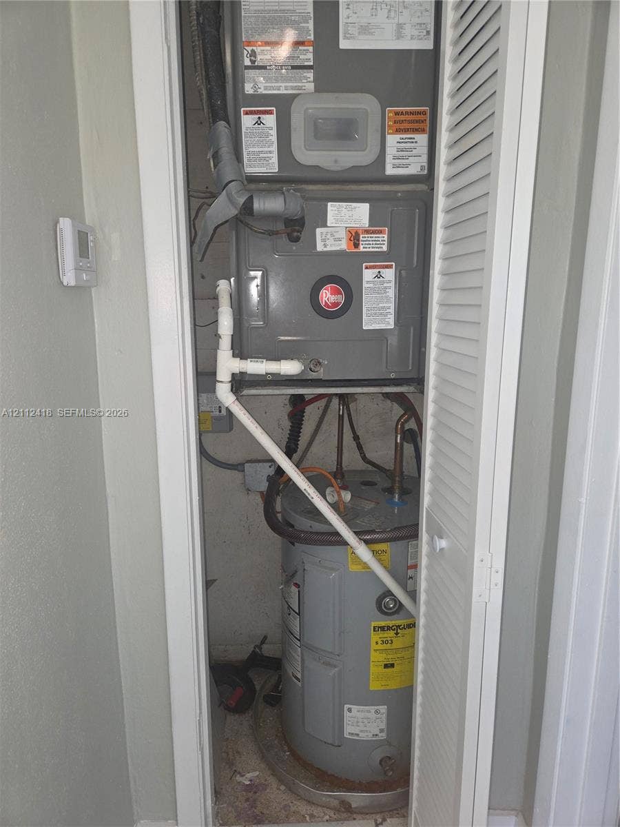 Utility closet featuring a dedicated HVAC unit and a water heater enclosed by a louvered door
