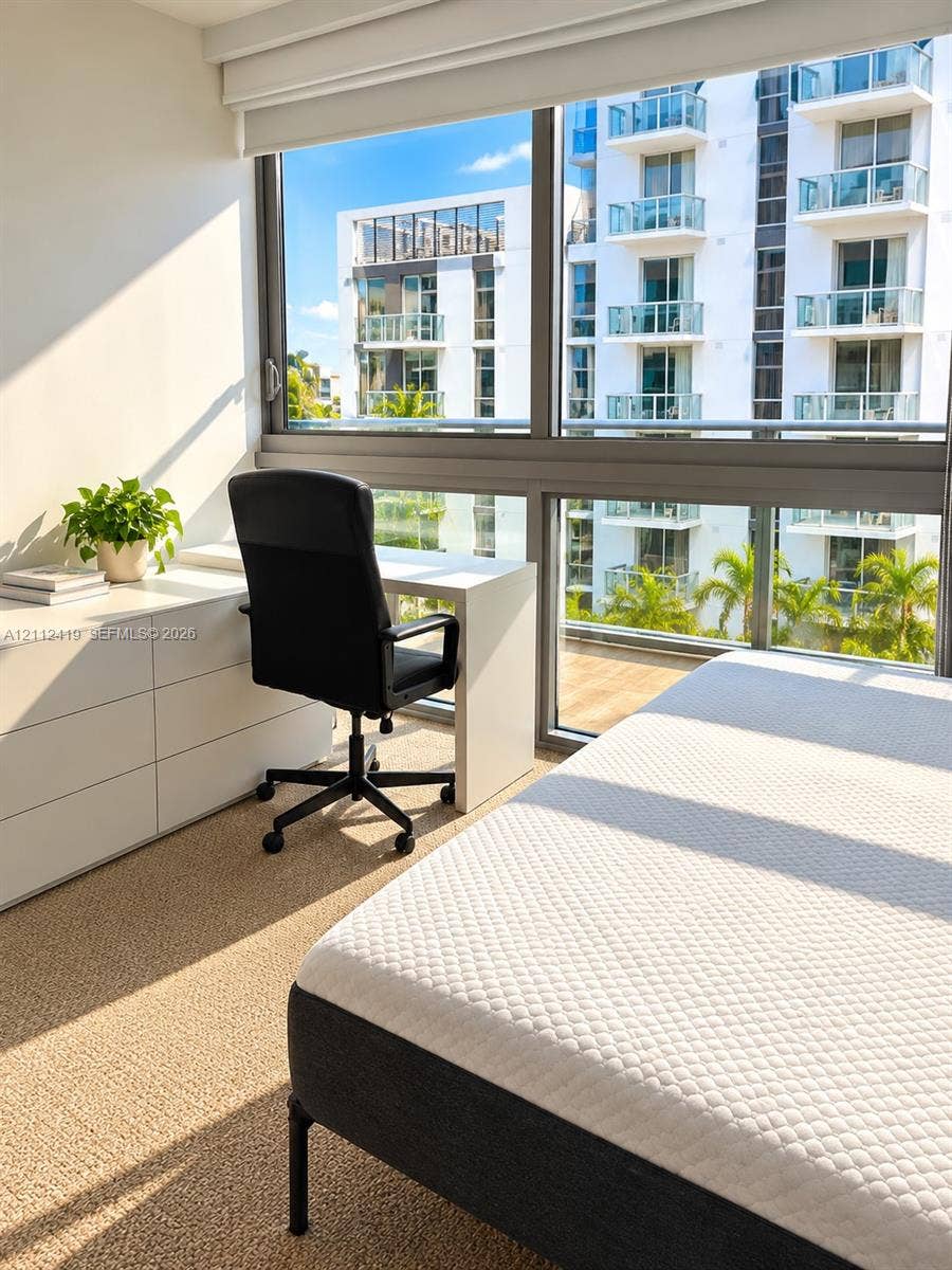 Floor-to-ceiling windows with expansive glass panes, neutral carpeting, and roller shade window treatments