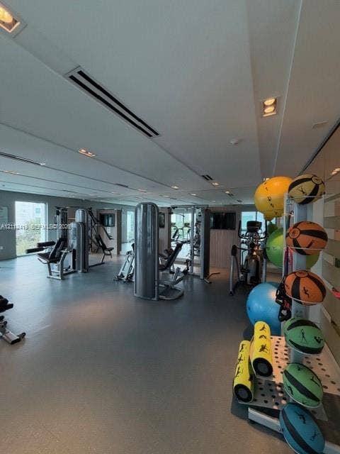 Fitness center featuring smooth resilient flooring, recessed ceiling lighting, and expansive wall mirrors