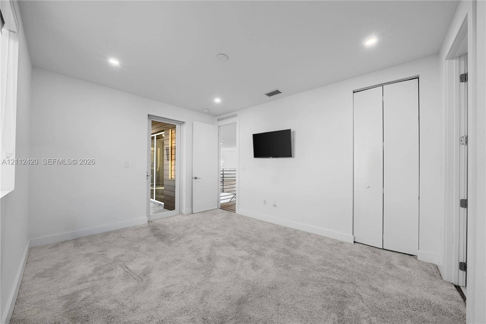10054 NW 76th Terrace, Doral, FL 33178 Neutral wall tones with recessed LED lighting, wall-to-wall carpeting, and a double-door closet