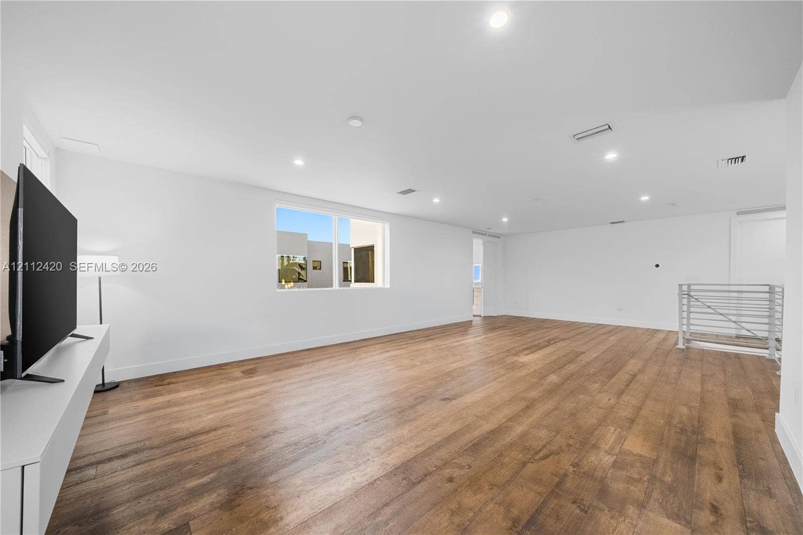 10054 NW 76th Terrace, Doral, FL 33178 Spacious interior featuring wood-finish flooring, recessed lighting, and a metal stair railing
