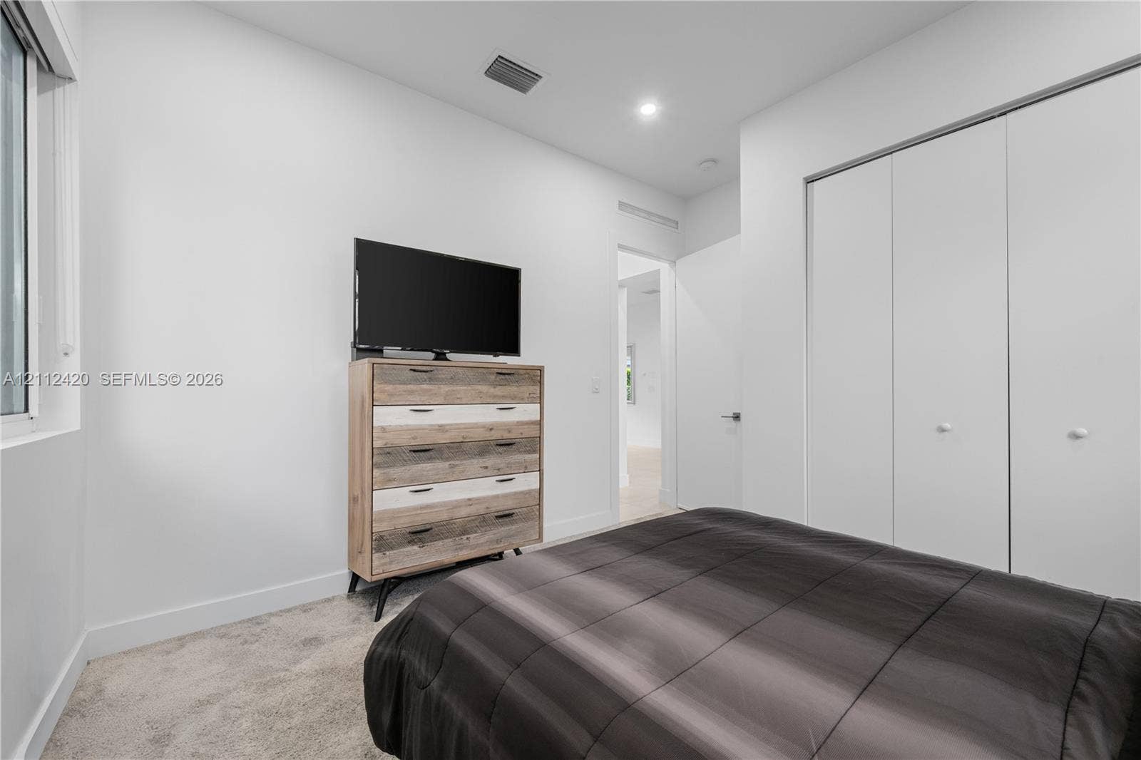 10054 NW 76th Terrace, Doral, FL 33178 Interior space featuring neutral wall tones, recessed lighting, carpeted flooring, and a floor-to-ceiling multi-panel sliding door closet