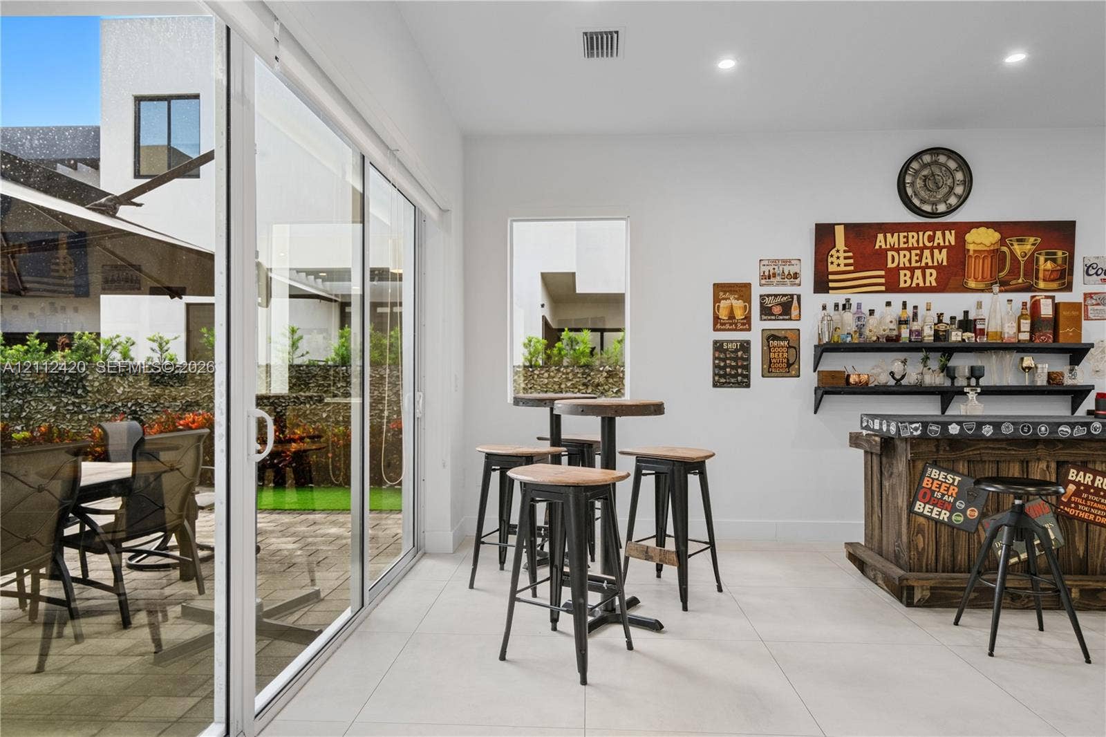 10054 NW 76th Terrace, Doral, FL 33178 Large-format sliding glass doors, neutral tile flooring, recessed ceiling lighting, and a fixed vertical window