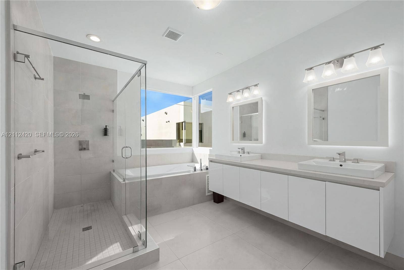 10054 NW 76th Terrace, Doral, FL 33178 Double vanity featuring high-gloss cabinetry, rectangular vessel sinks, quartz countertops, and dual wall-mounted light fixtures