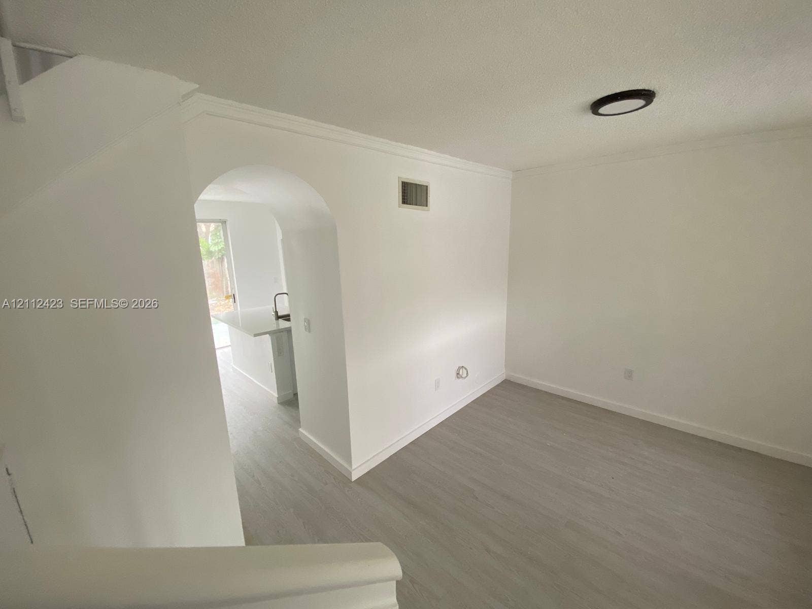 8555 SW 152nd Avenue, #104, Miami, FL 33193 Wood-finish flooring, architectural arched opening, and flush-mount ceiling lighting