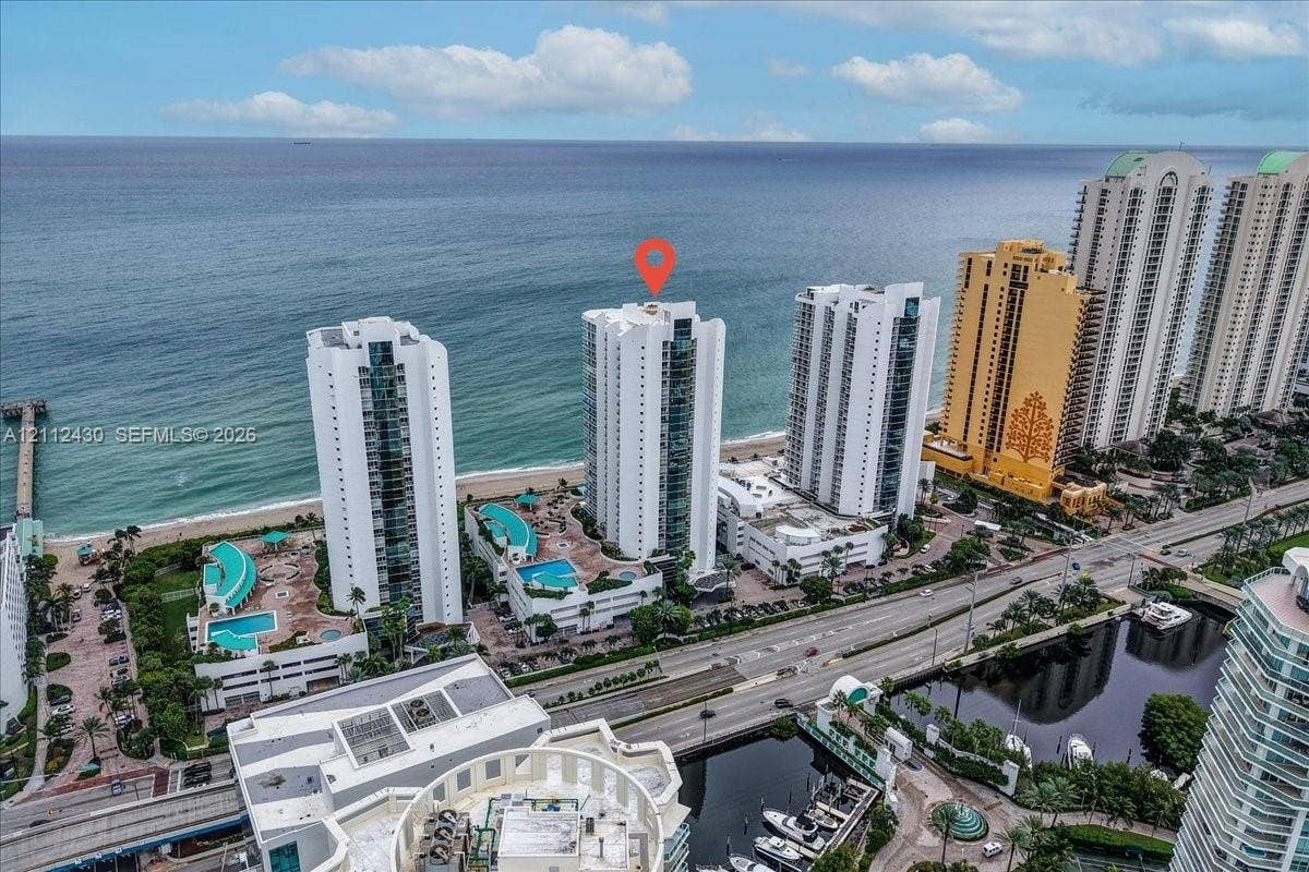 High-rise residential tower featuring direct oceanfront positioning and exterior swimming pools