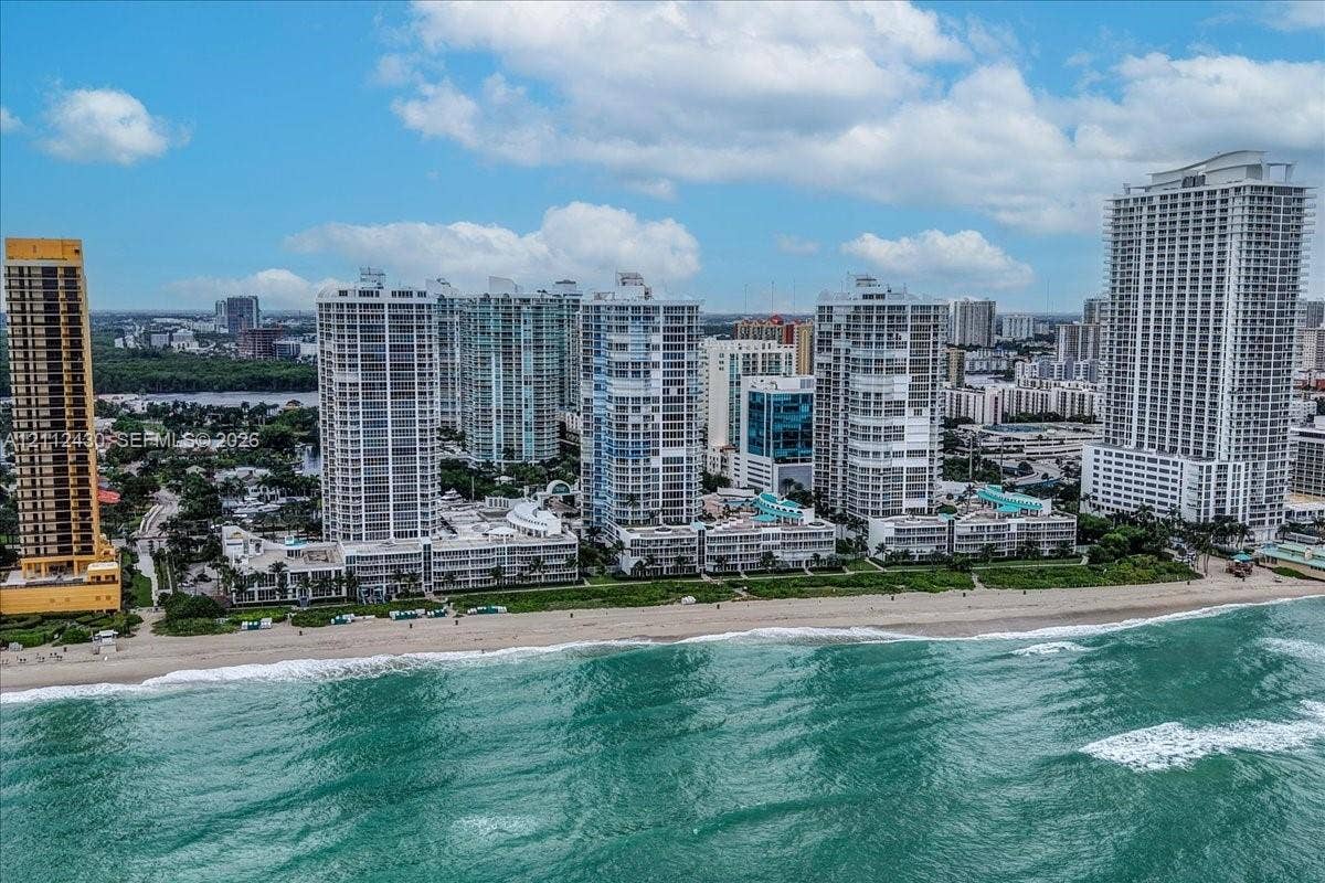 High-rise residential towers positioned directly along the Atlantic coastline, featuring expansive sandy beaches, oceanfront access, and proximity to coastal vegetation