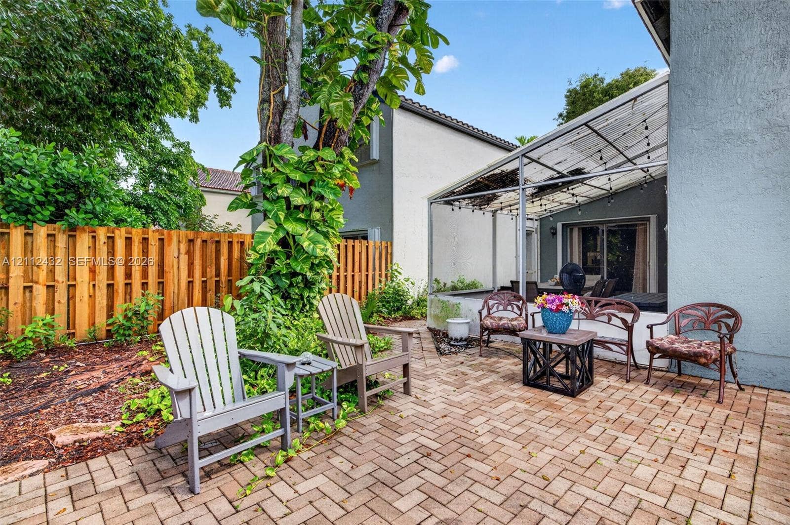 10545 NW 11th Court, Plantation, FL 33322 Paver patio featuring a metal-framed covered lanai and mature landscaping