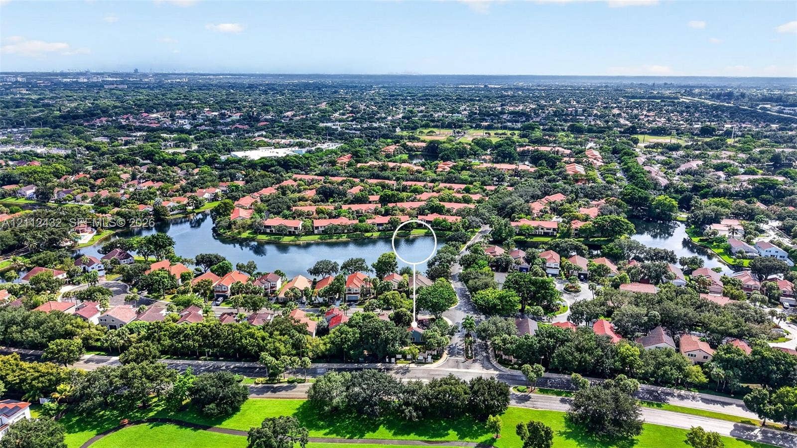 10545 NW 11th Court, Plantation, FL 33322 Aerial perspective of a waterfront property featuring a central lake, extensive tree canopy, and dense residential landscaping