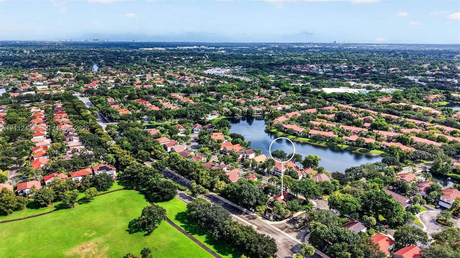 10545 NW 11th Court, Plantation, FL 33322 Aerial perspective featuring a residential property situated on a lakefront lot with mature canopy trees and expansive surrounding green space