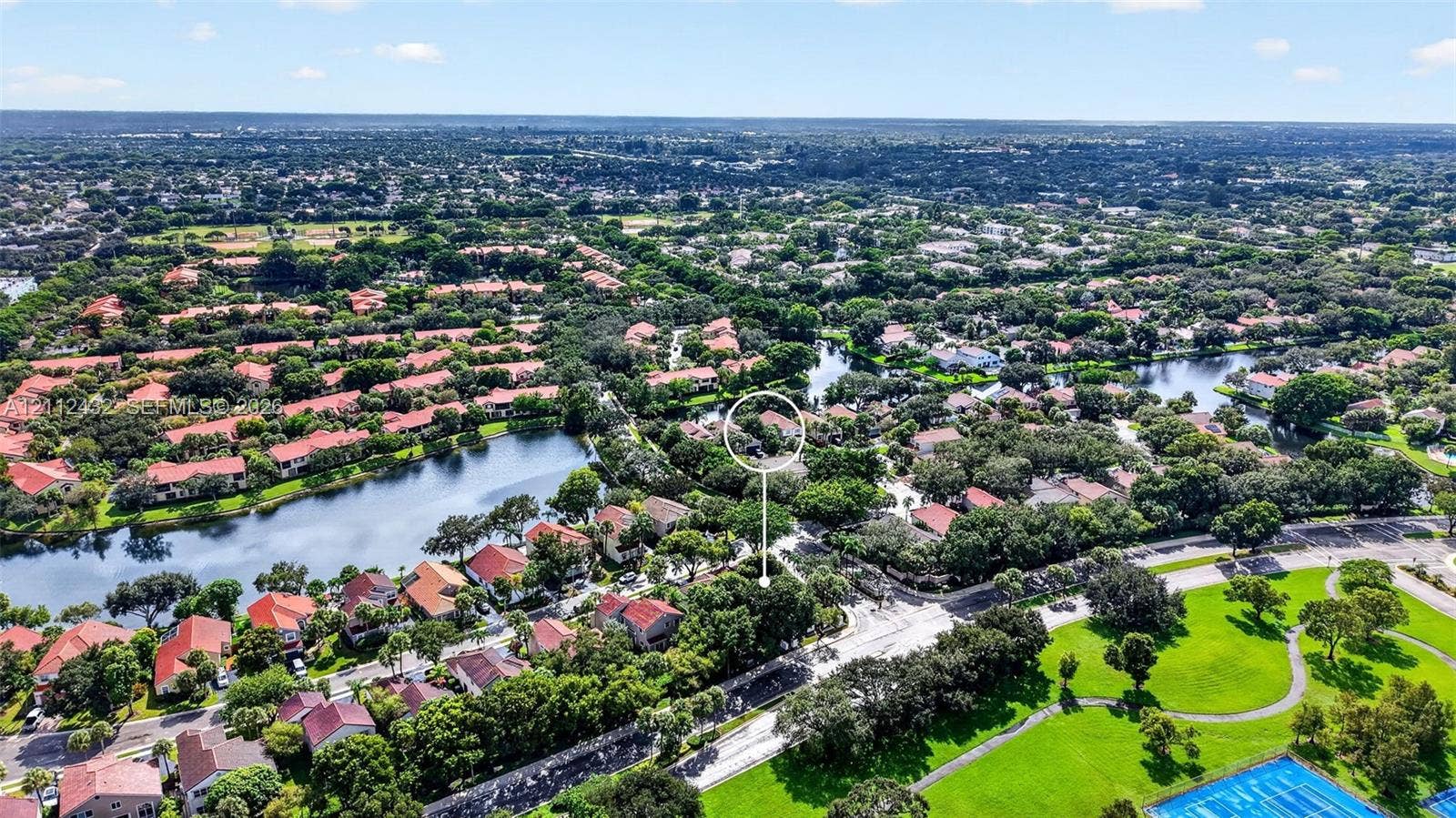 10545 NW 11th Court, Plantation, FL 33322 Aerial perspective featuring a residential lot with mature trees, situated within a community of tiled-roof structures featuring interspersed lakes and green spaces