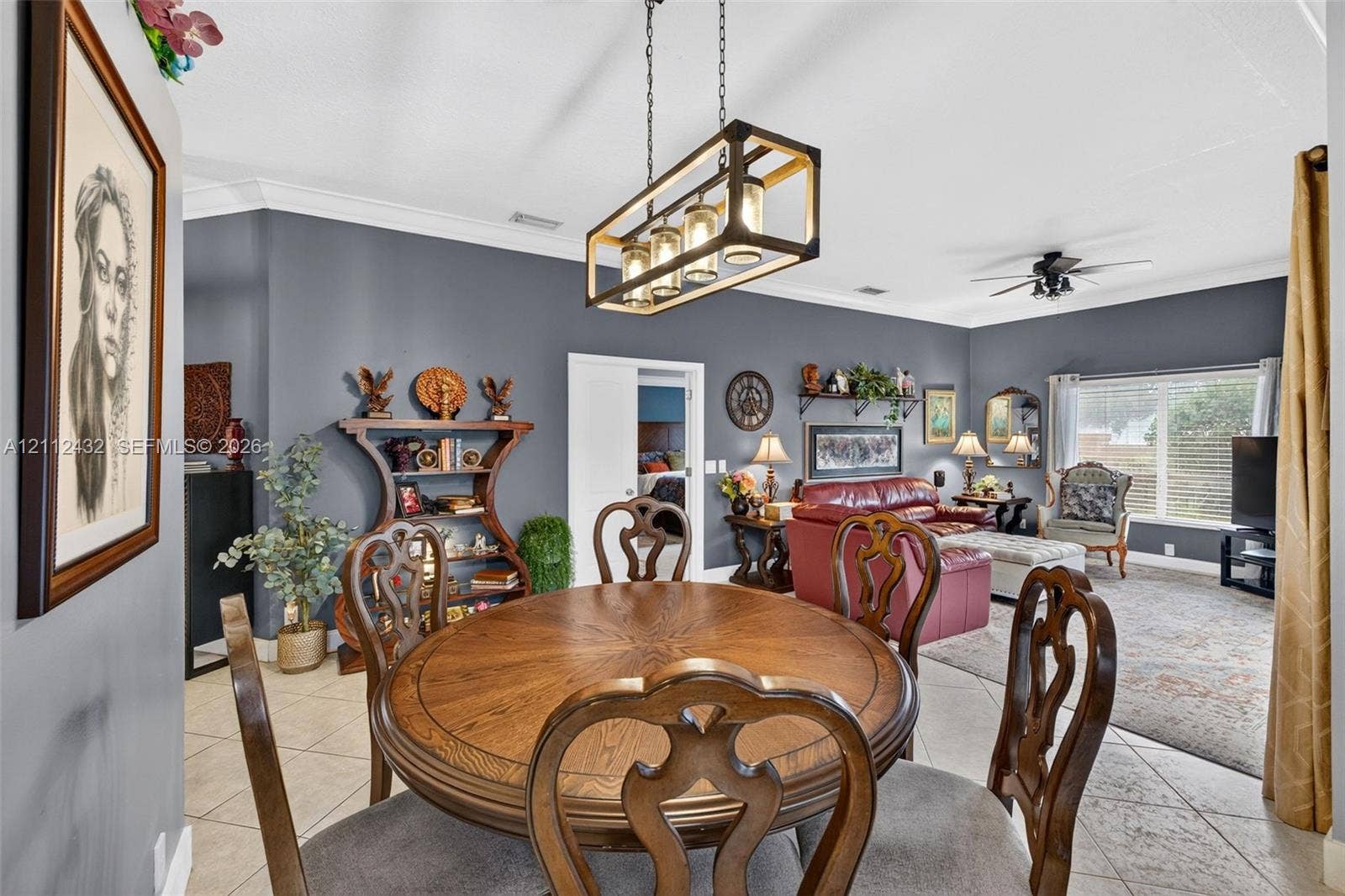 10545 NW 11th Court, Plantation, FL 33322 Open floor plan featuring tile flooring, crown molding, and a geometric-frame pendant light fixture