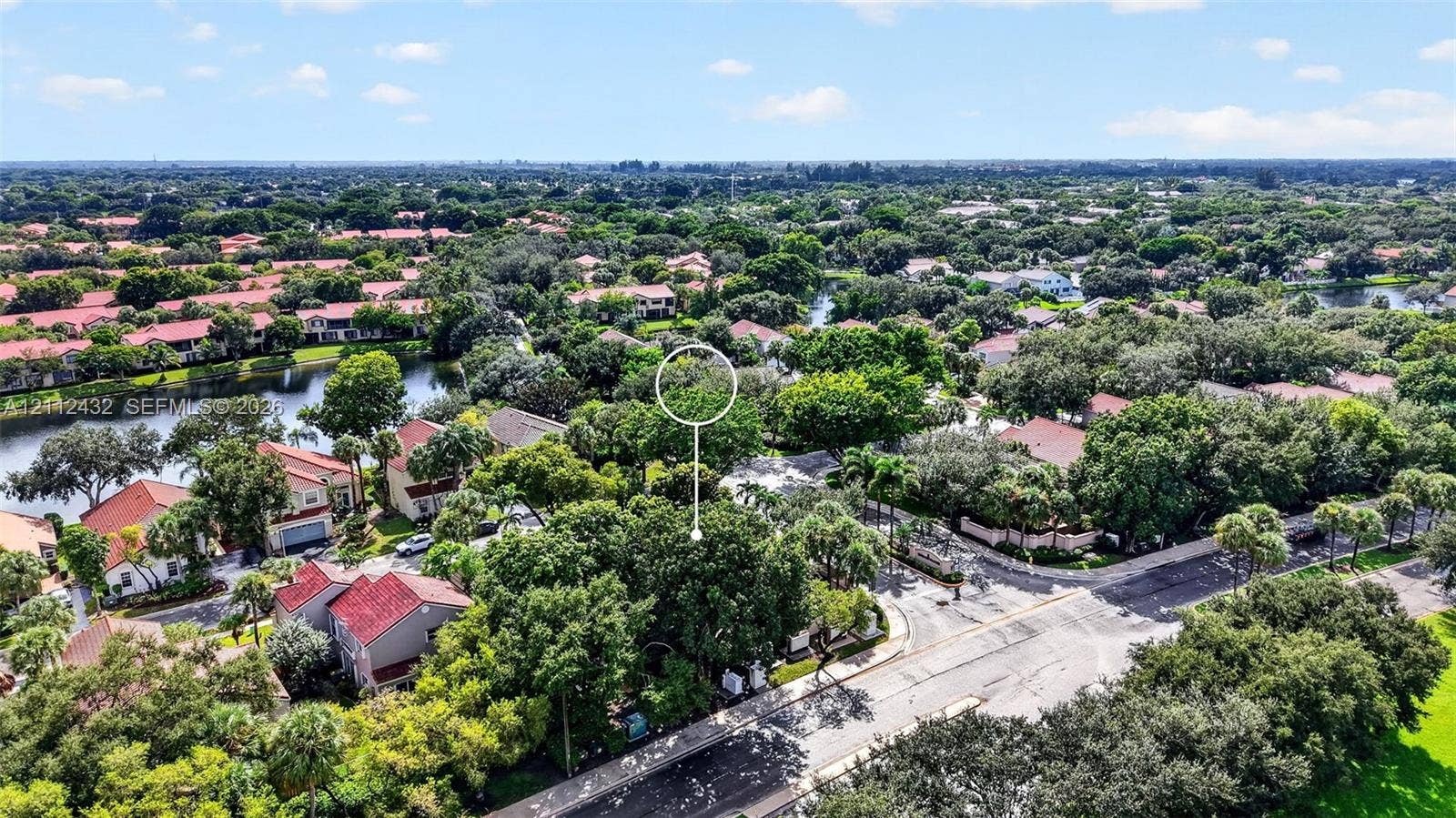 10545 NW 11th Court, Plantation, FL 33322 Aerial perspective of a residential community featuring mature trees, a winding water feature, paved roadways, and dense canopy cover