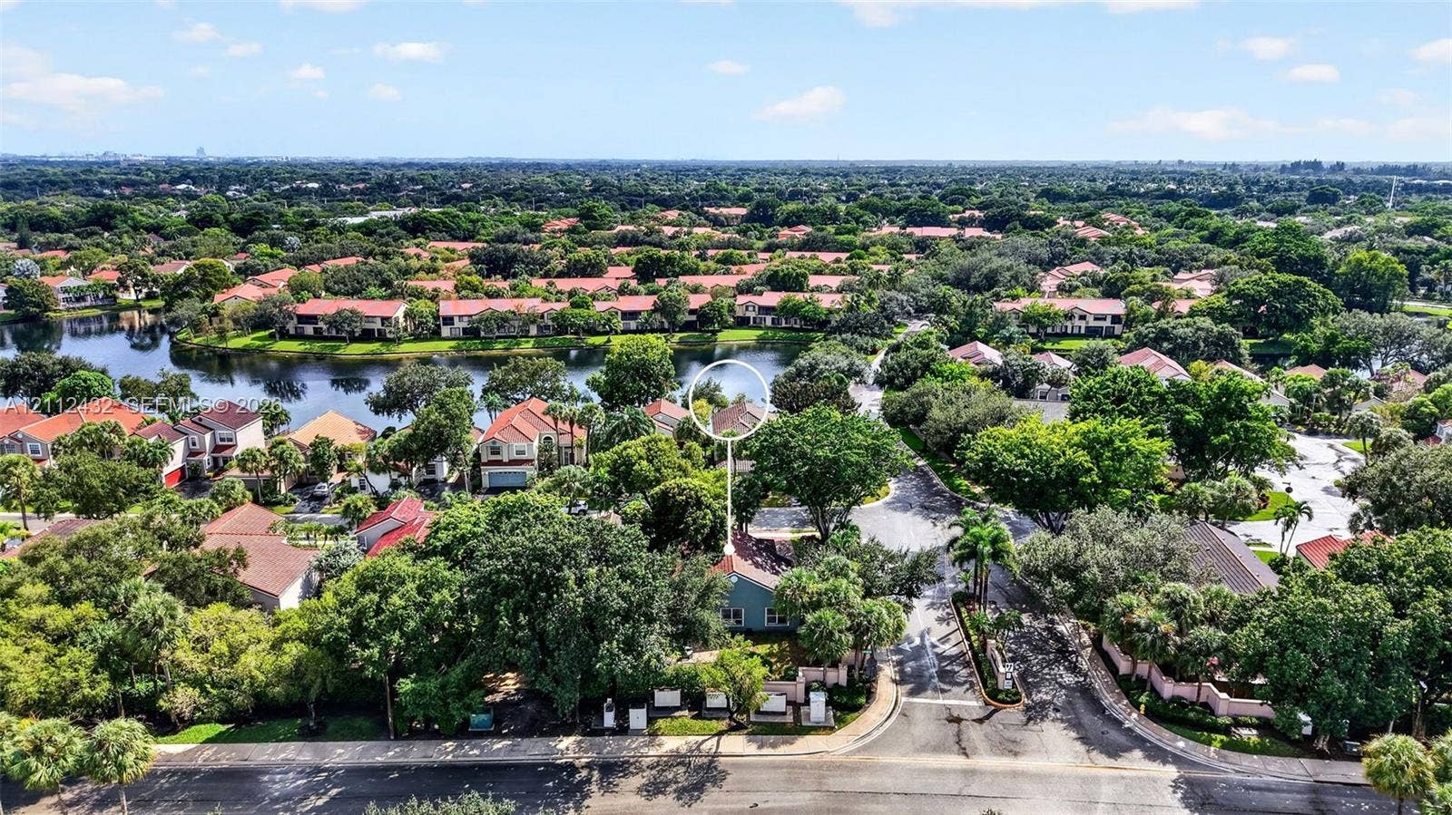 10545 NW 11th Court, Plantation, FL 33322 Aerial perspective of a residential community featuring a sprawling lake, established canopy trees, and paved street access