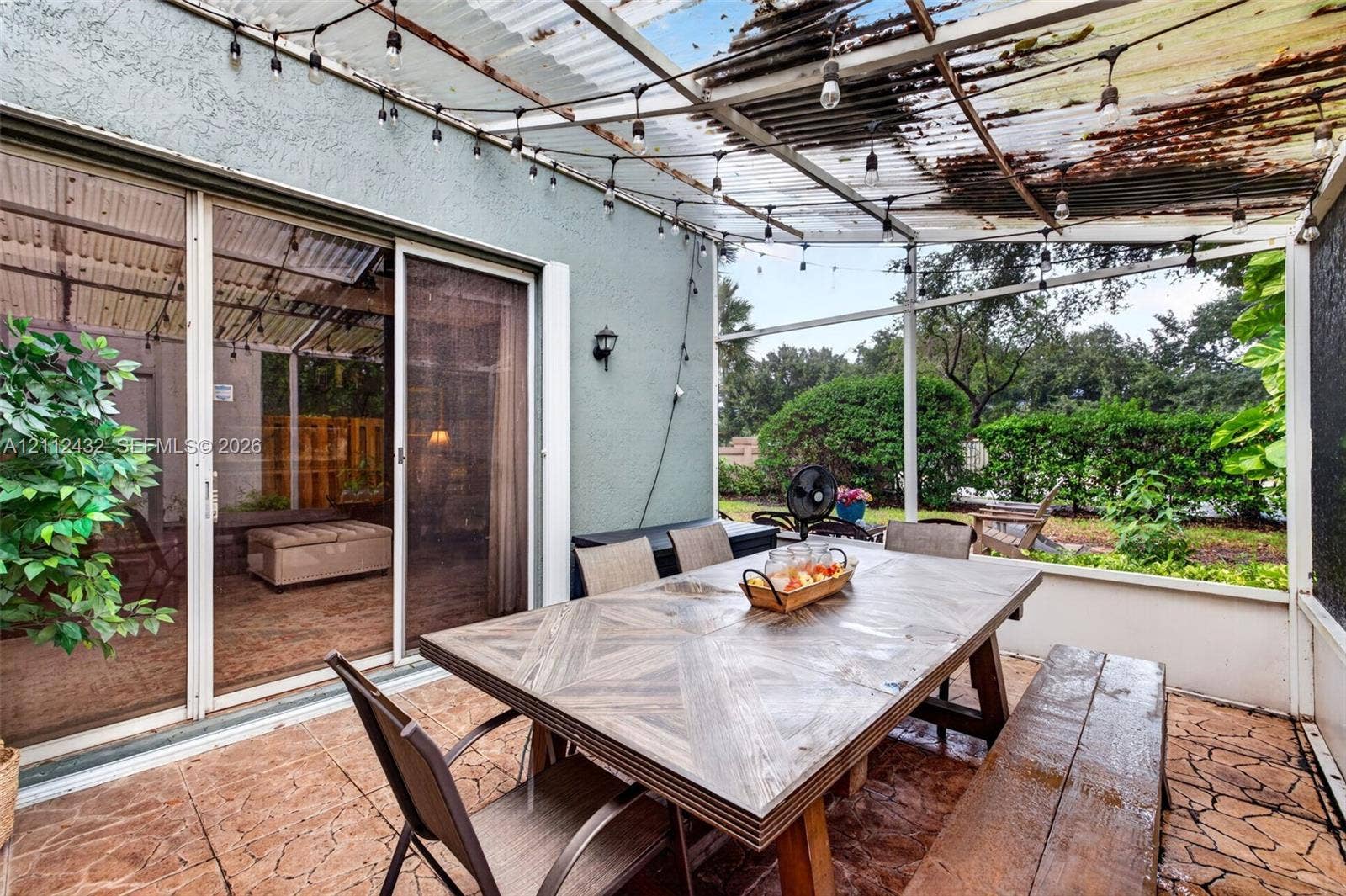 10545 NW 11th Court, Plantation, FL 33322 Screened-in patio featuring tile flooring, a translucent corrugated roof, and sliding glass door entry - screened in