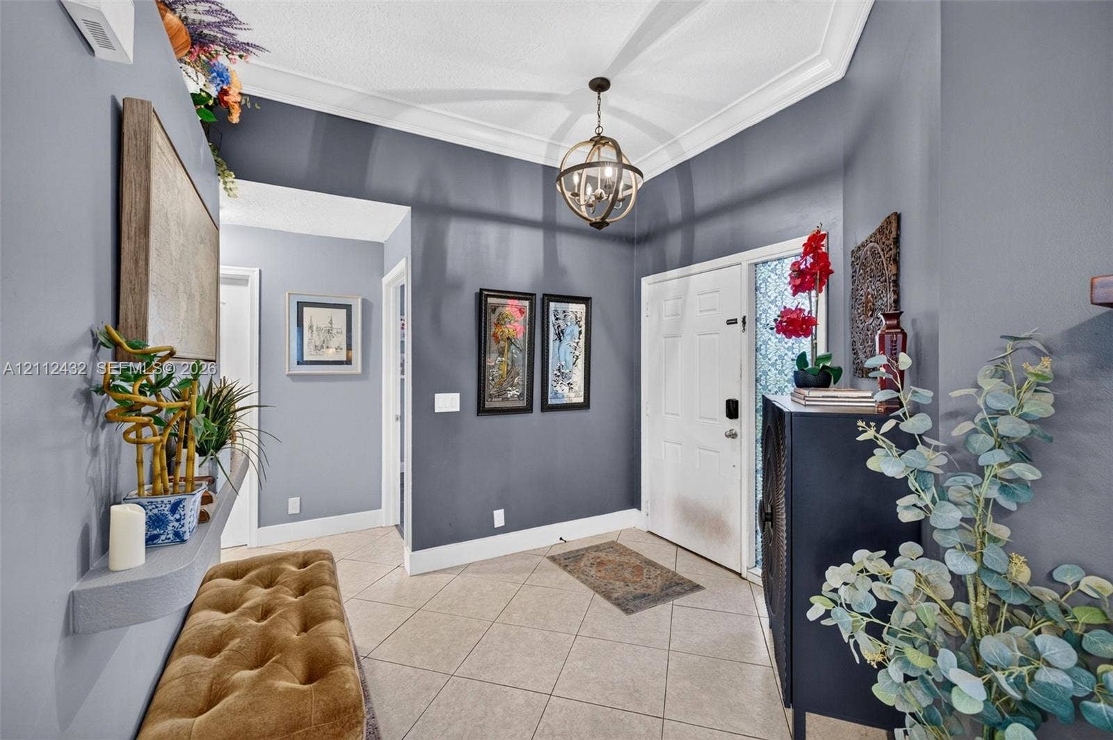 10545 NW 11th Court, Plantation, FL 33322 Foyer featuring large-format ceramic tile flooring, crown molding, a decorative orb chandelier