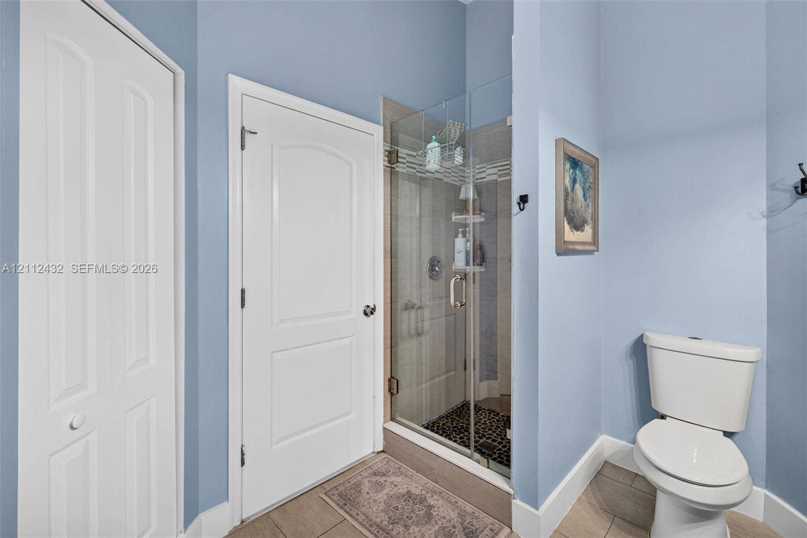 10545 NW 11th Court, Plantation, FL 33322 Bathroom featuring a frameless glass shower enclosure, tiled wall surround, stone-tiled shower floor
