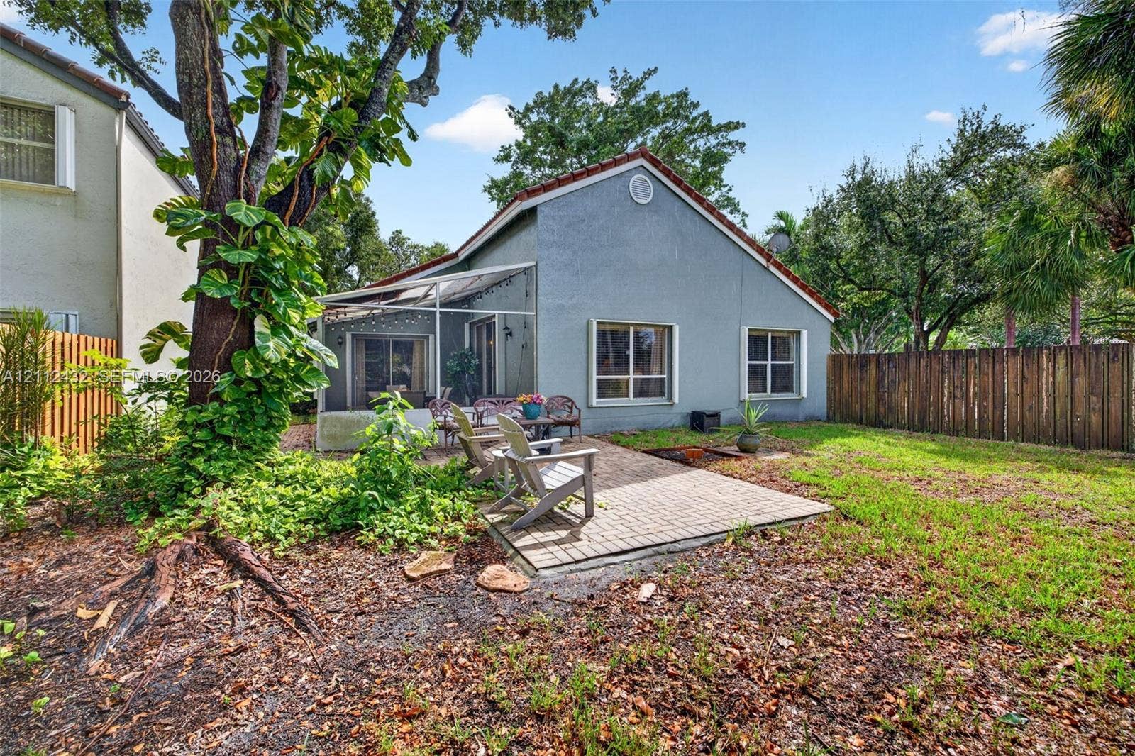 10545 NW 11th Court, Plantation, FL 33322 Backyard featuring a paved patio, screened enclosure
