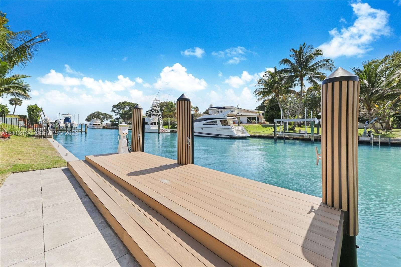 770 Lake Road, Miami, FL 33137 Waterfront dock featuring composite decking, integrated piling covers, and a paved concrete approach