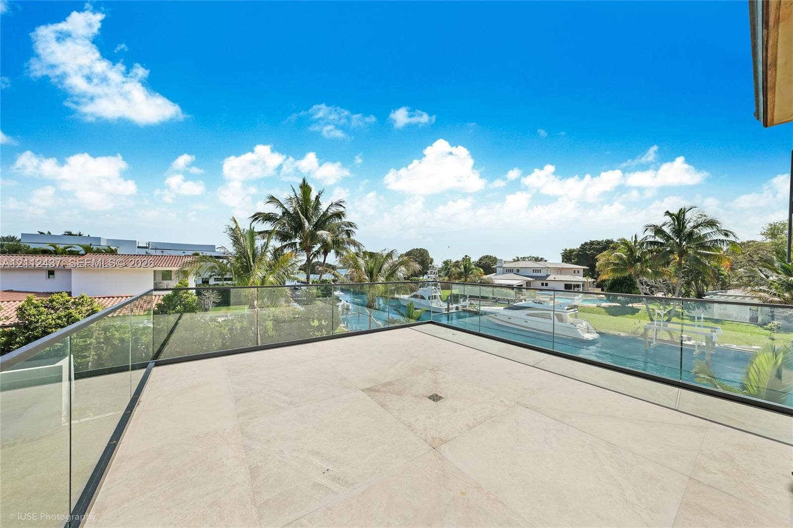 770 Lake Road, Miami, FL 33137 Open-air terrace featuring large-format stone tile flooring and a seamless glass panel railing