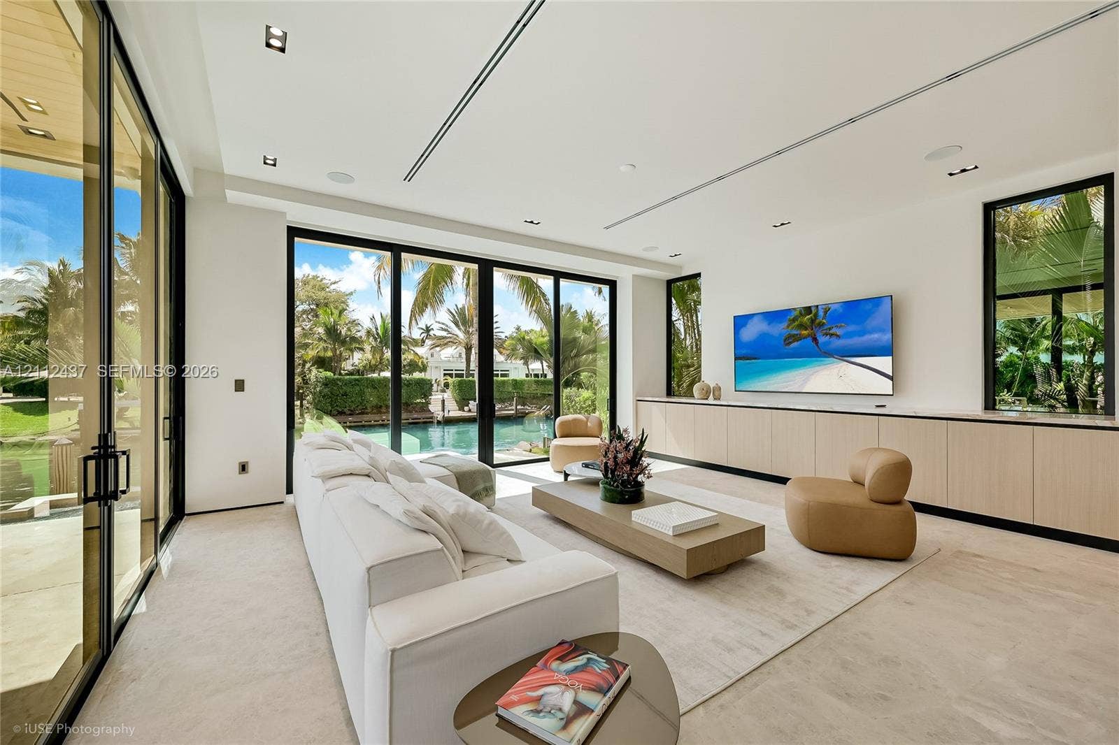 770 Lake Road, Miami, FL 33137 Custom light-finish cabinetry, natural stone backsplash and range hood surround, integrated stainless steel appliances, stone slab countertop, and recessed ceiling lighting