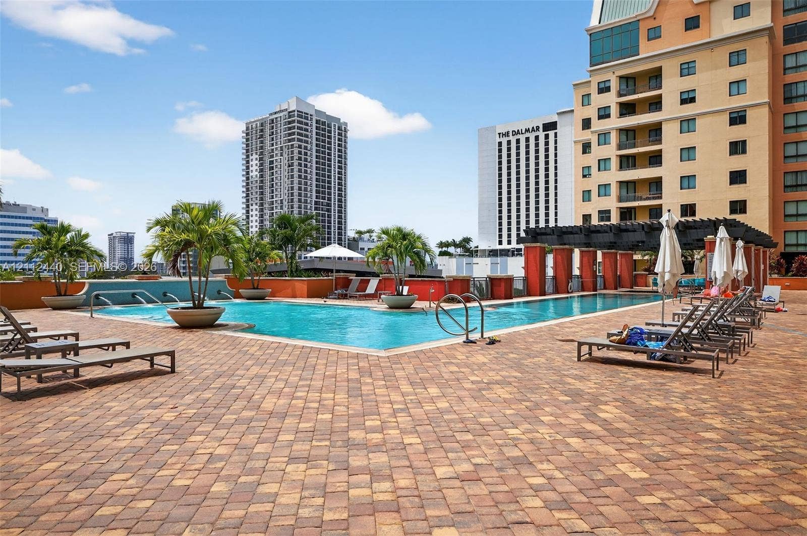 110 N Federal Highway, #914, Fort Lauderdale, FL 33301 pool deck featuring stone paver flooring, integrated water fountains, a decorative pergola, and tropical planters