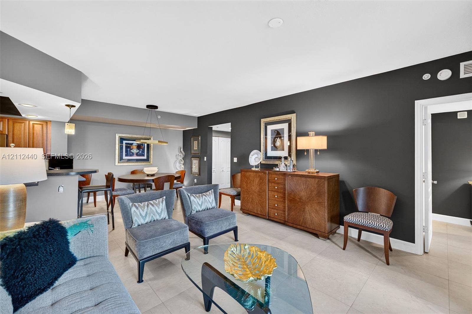 110 N Federal Highway, #914, Fort Lauderdale, FL 33301 Open-concept living space featuring high-contrast charcoal accent walls, large-format porcelain flooring, a tiered breakfast bar (chandelier does not convey)