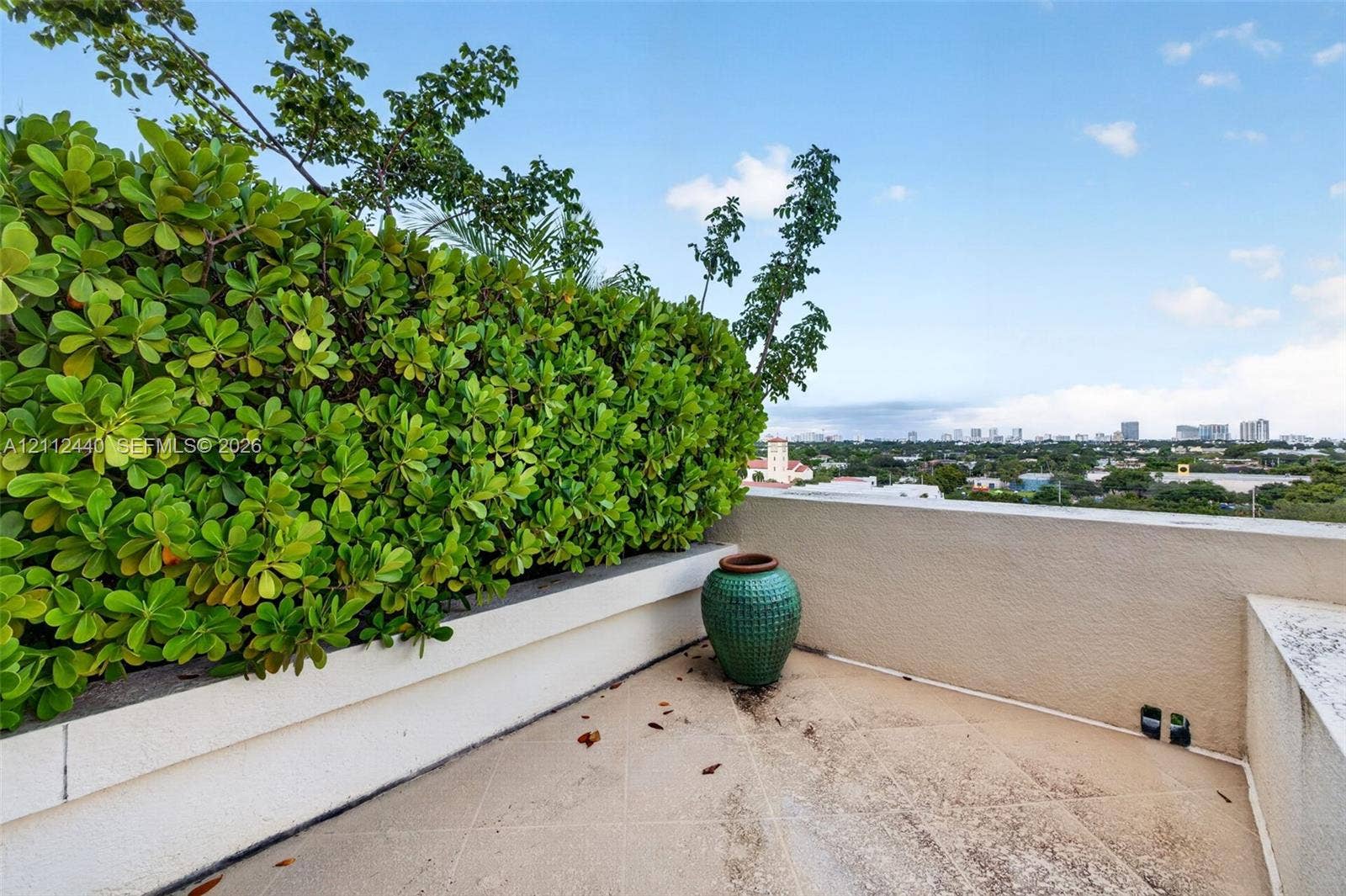 110 N Federal Highway, #914, Fort Lauderdale, FL 33301 Rooftop terrace featuring concrete tiled flooring, stucco perimeter walls, and a built-in planter with mature hedge greenery