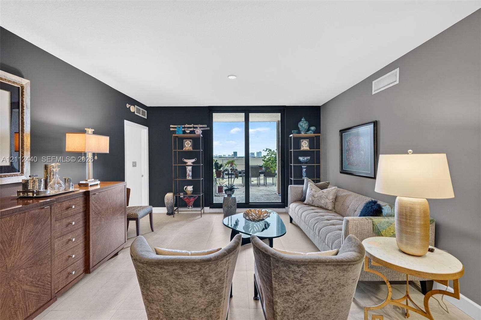110 N Federal Highway, #914, Fort Lauderdale, FL 33301 Living area featuring large-format porcelain flooring, high-contrast dark accent walls, and floor-to-ceiling glass sliding doors opening to an oversized outdoor patio
