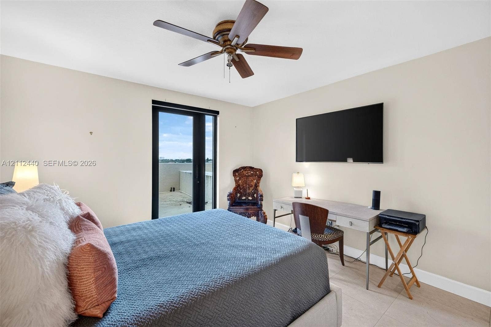 110 N Federal Highway, #914, Fort Lauderdale, FL 33301 Neutral-toned interior featuring large-format porcelain flooring, a mounted ceiling fan with wood-tone blades, and a sliding glass door providing access to an exterior terrace