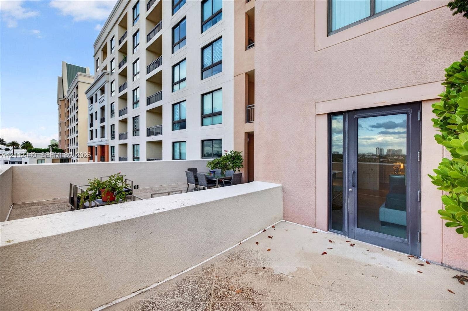 110 N Federal Highway, #914, Fort Lauderdale, FL 33301 Expansive private terrace featuring concrete flooring and a solid stucco perimeter wall, accessed through a full-height glass door