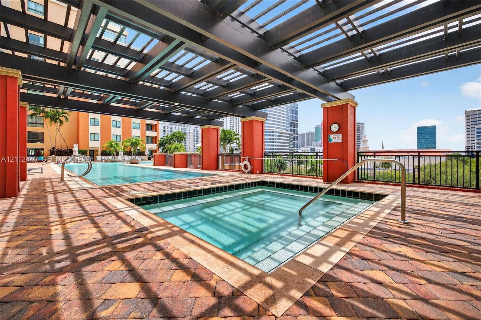 110 N Federal Highway, #914, Fort Lauderdale, FL 33301 Covered pool and spa area featuring a dark-finish pergola, paver decking, and metal railings